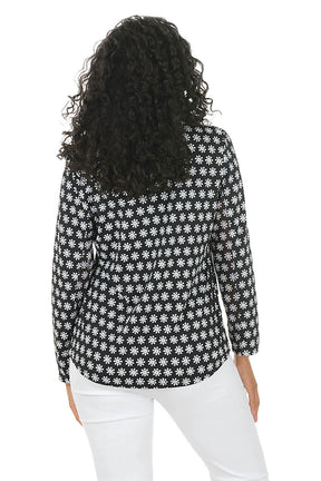 Woman wearing a black and white patterned sun shirt with a zipper on a white background. Back shot.