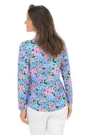 Woman wearing a colorful floral blouse with long sleeves on a white background