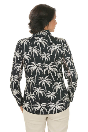 Woman wearing a black shirt with palm tree pattern on a white background