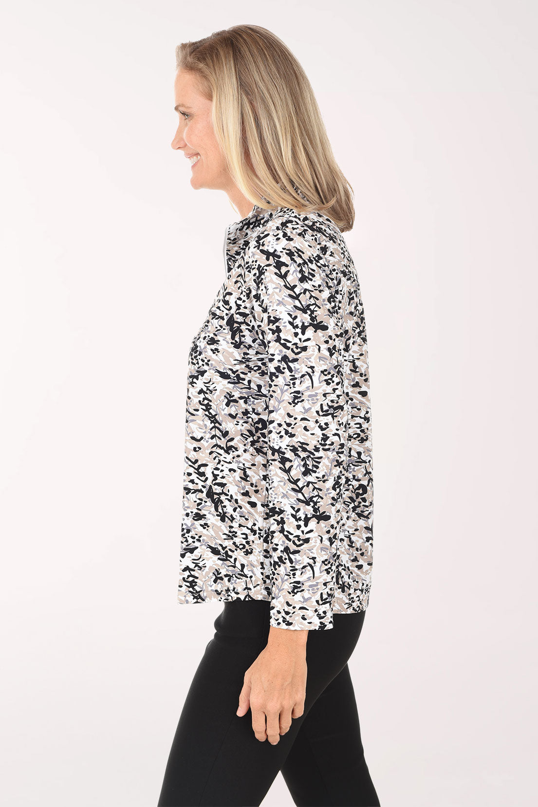 Woman wearing a black and white floral blouse on a white background