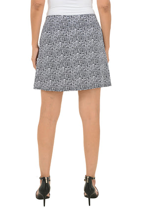 Person wearing a black and white patterned skirt on a white background. Back shot.