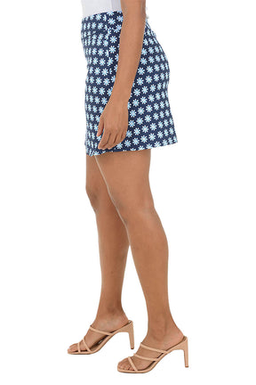 Person wearing a blue and white patterned skirt on a white background. Side shot.