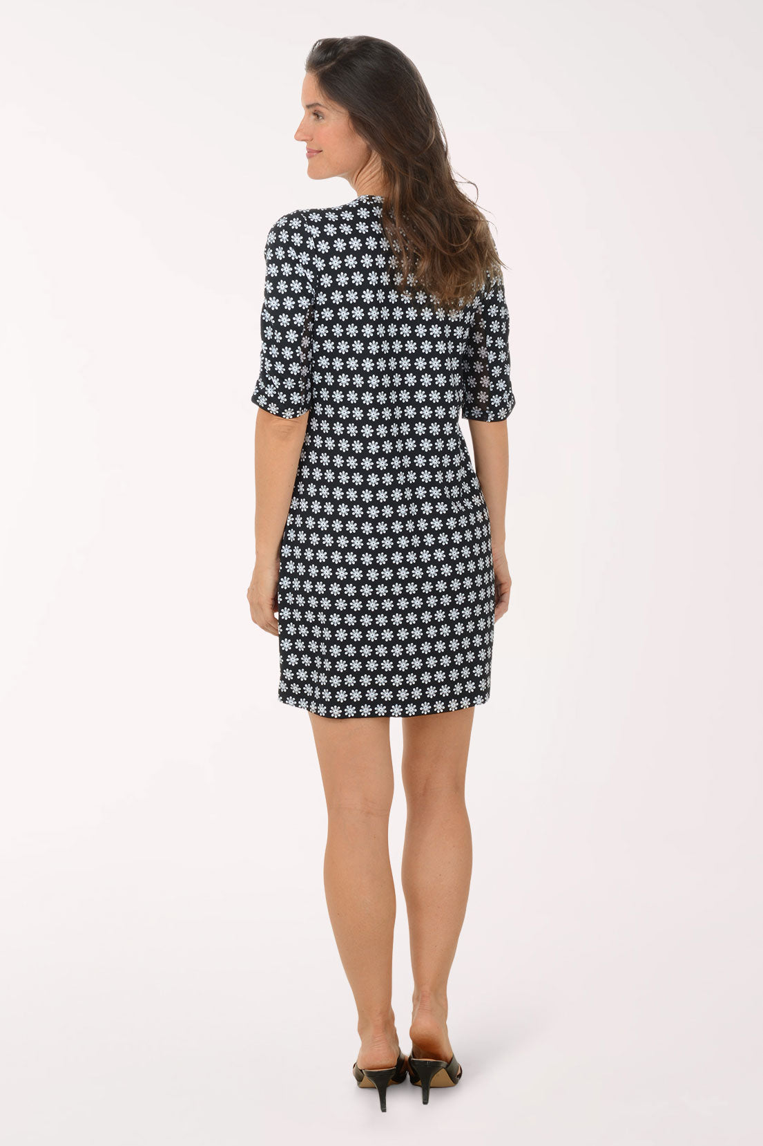 Woman wearing a black and white patterned dress on a white background