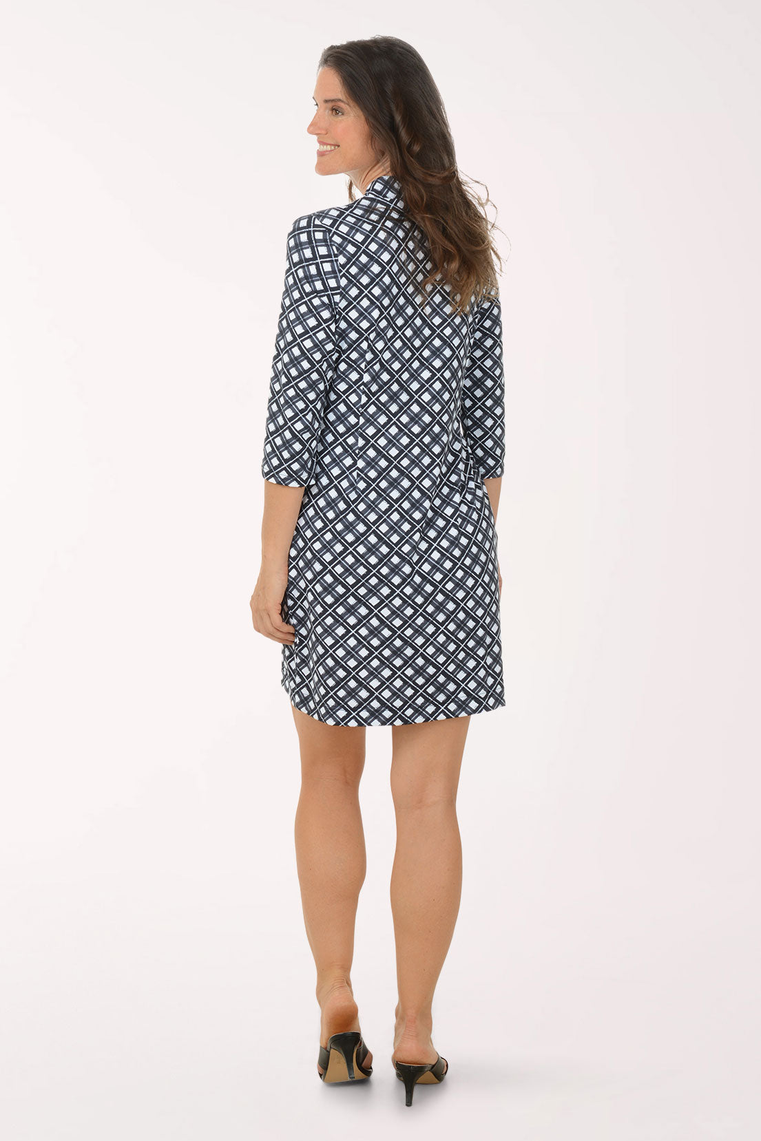 Woman wearing a navy and white patterned dress on a white background