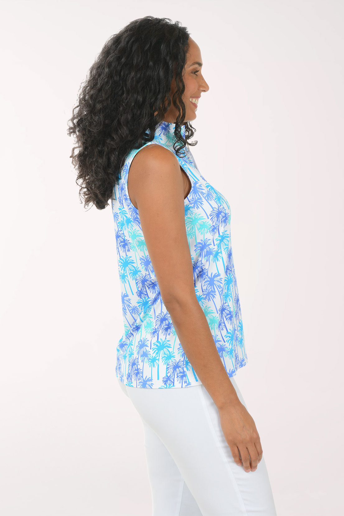 Woman wearing a sleeveless blue and white patterned top against a white background