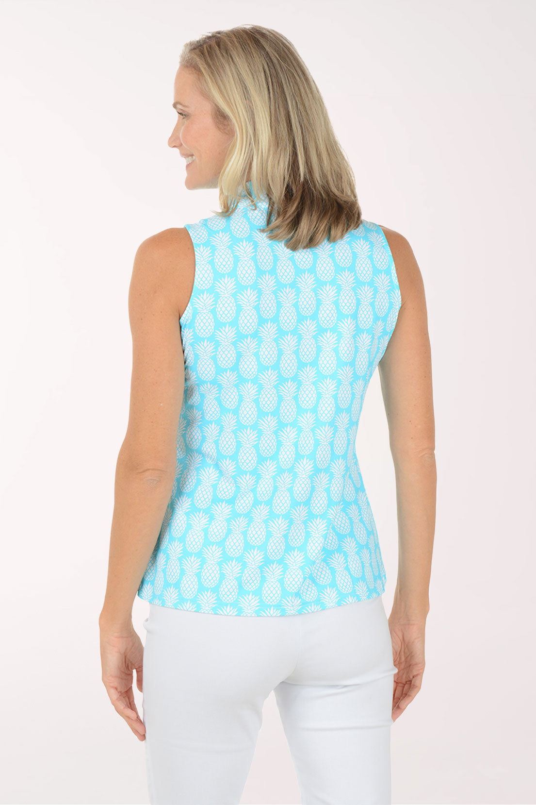 Woman wearing a light blue sleeveless patterned top against a white background