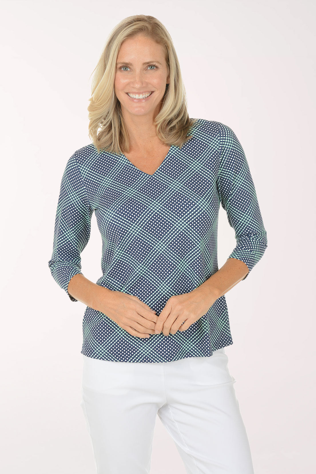 Woman wearing a blue checkered top and white pants on a white background
