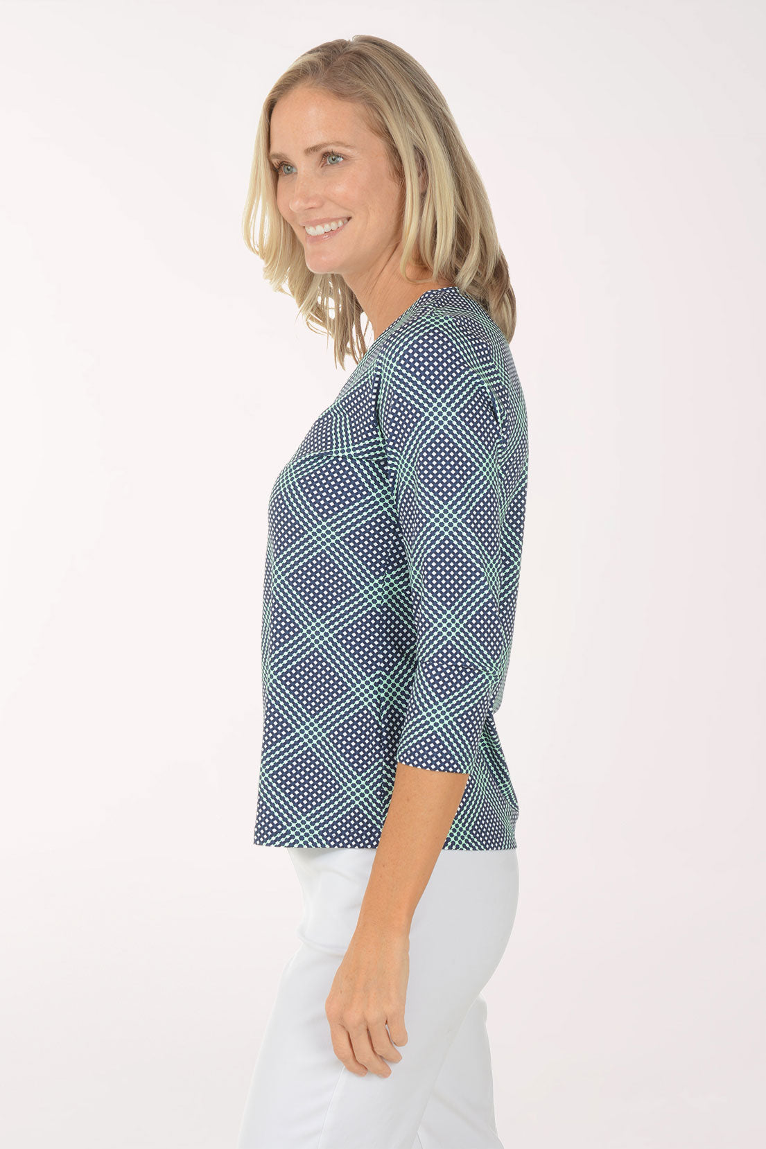 Woman wearing a blue checkered top and white pants on a white background