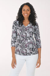Woman wearing a patterned blouse with a plain background