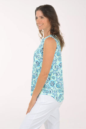Woman wearing a sleeveless top with a blue sea-themed pattern on a white background