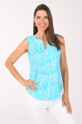 Woman wearing a light blue sleeveless top with palm tree pattern on a white background