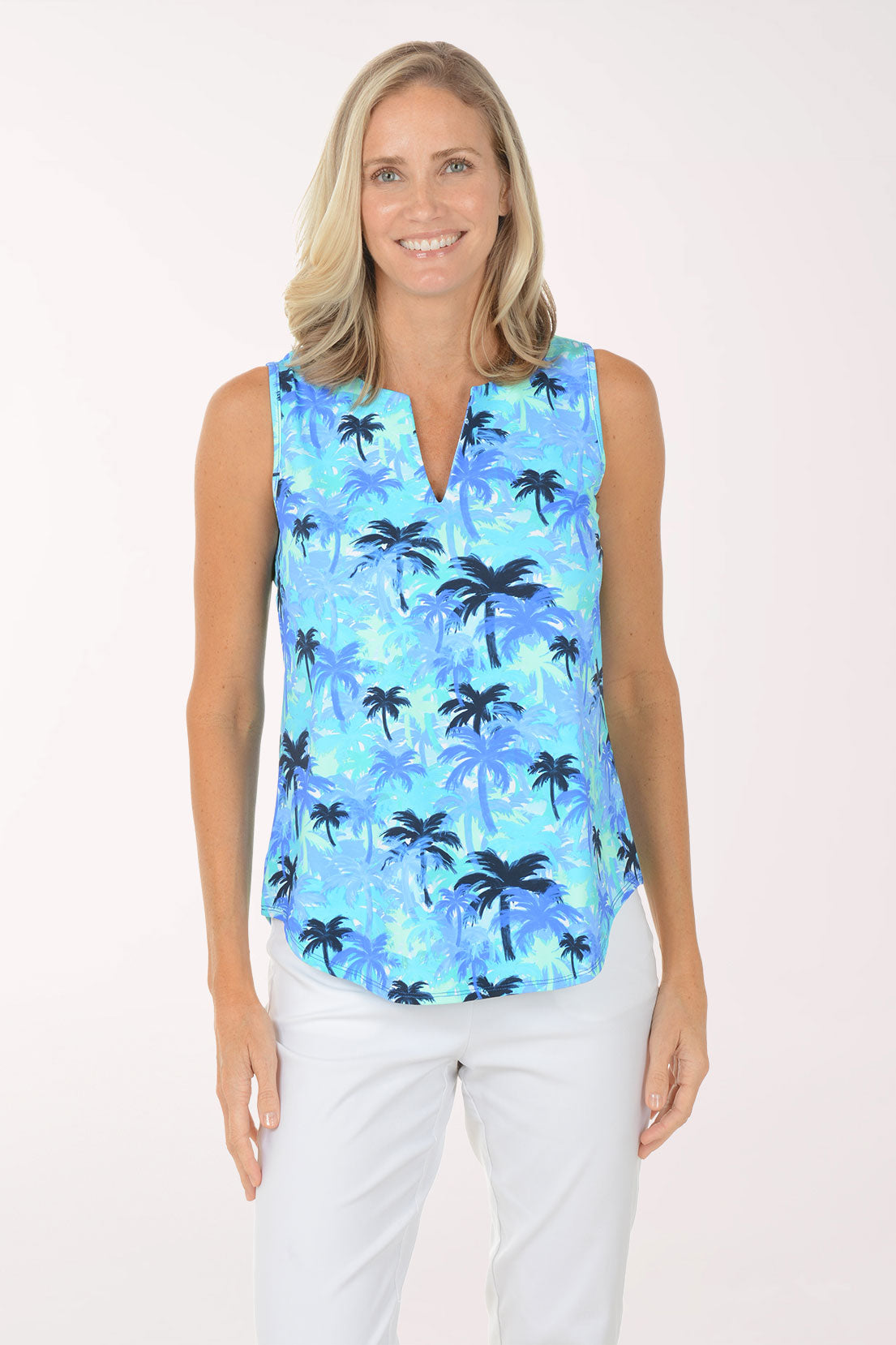 Woman wearing a sleeveless blue palm tree patterned top on a white background