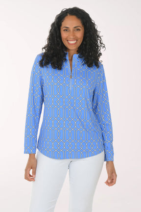 Woman wearing a blue patterned long-sleeve top on a white background