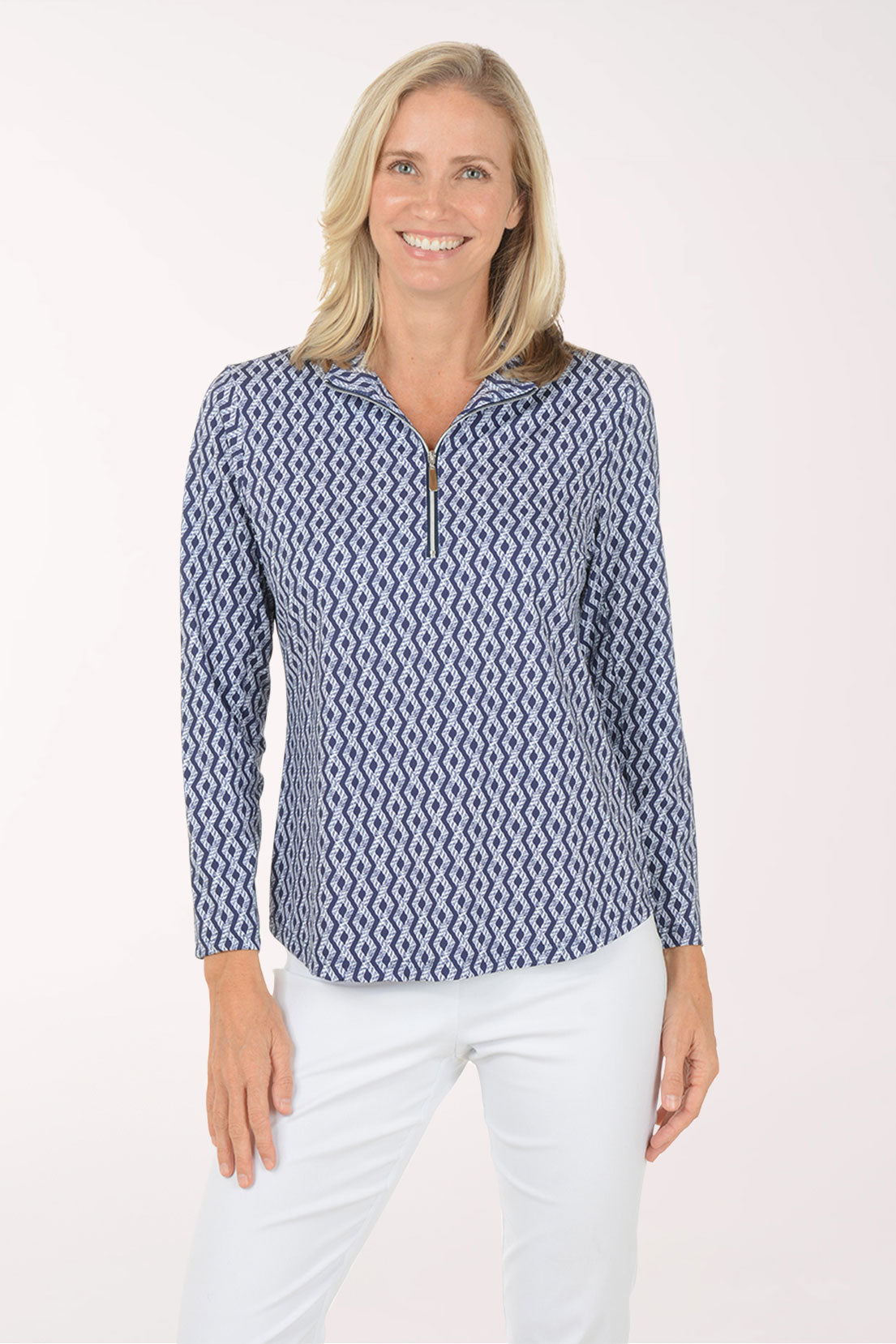 Woman wearing a blue patterned long-sleeve shirt and white pants on a white background