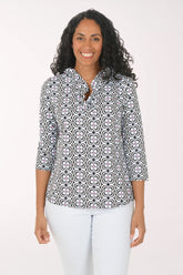 Woman wearing a patterned blouse and white pants on a white background