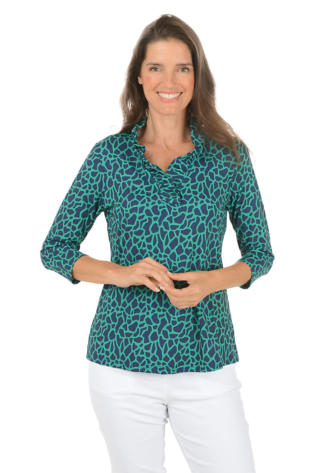 Woman wearing a teal leopard print shirt and white pants on a white background.