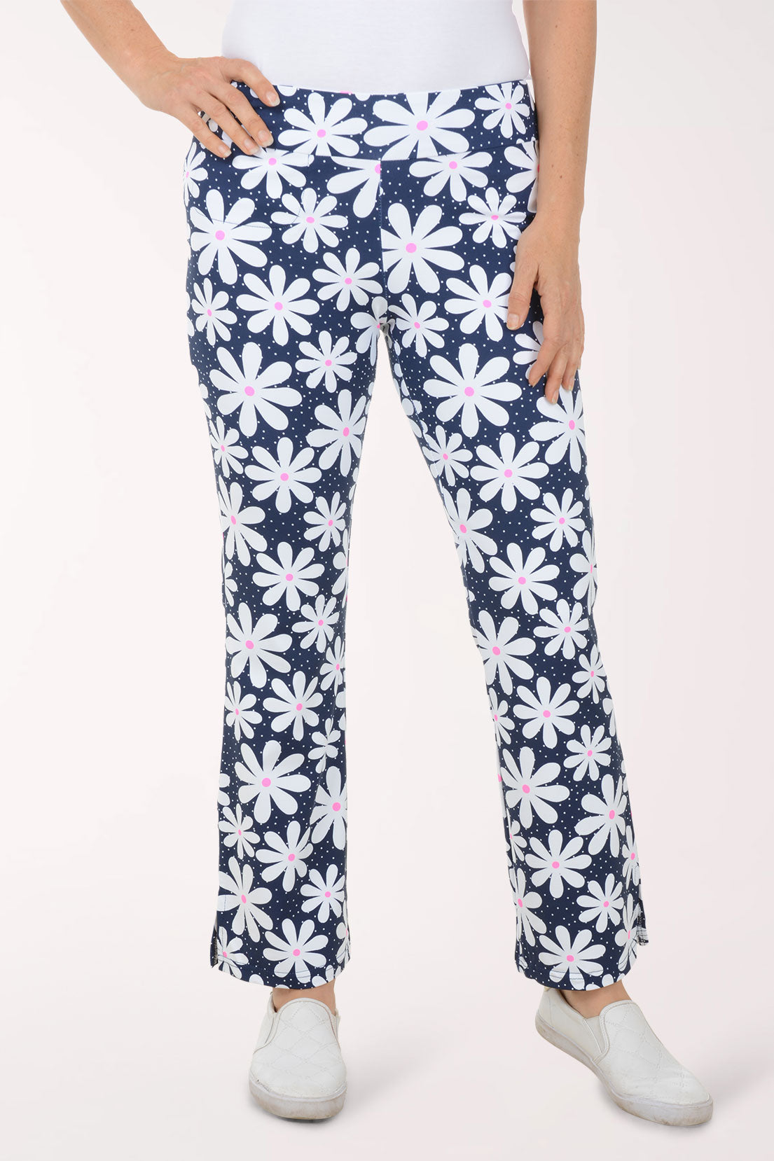 Navy pants with white floral pattern worn by a person on a white background