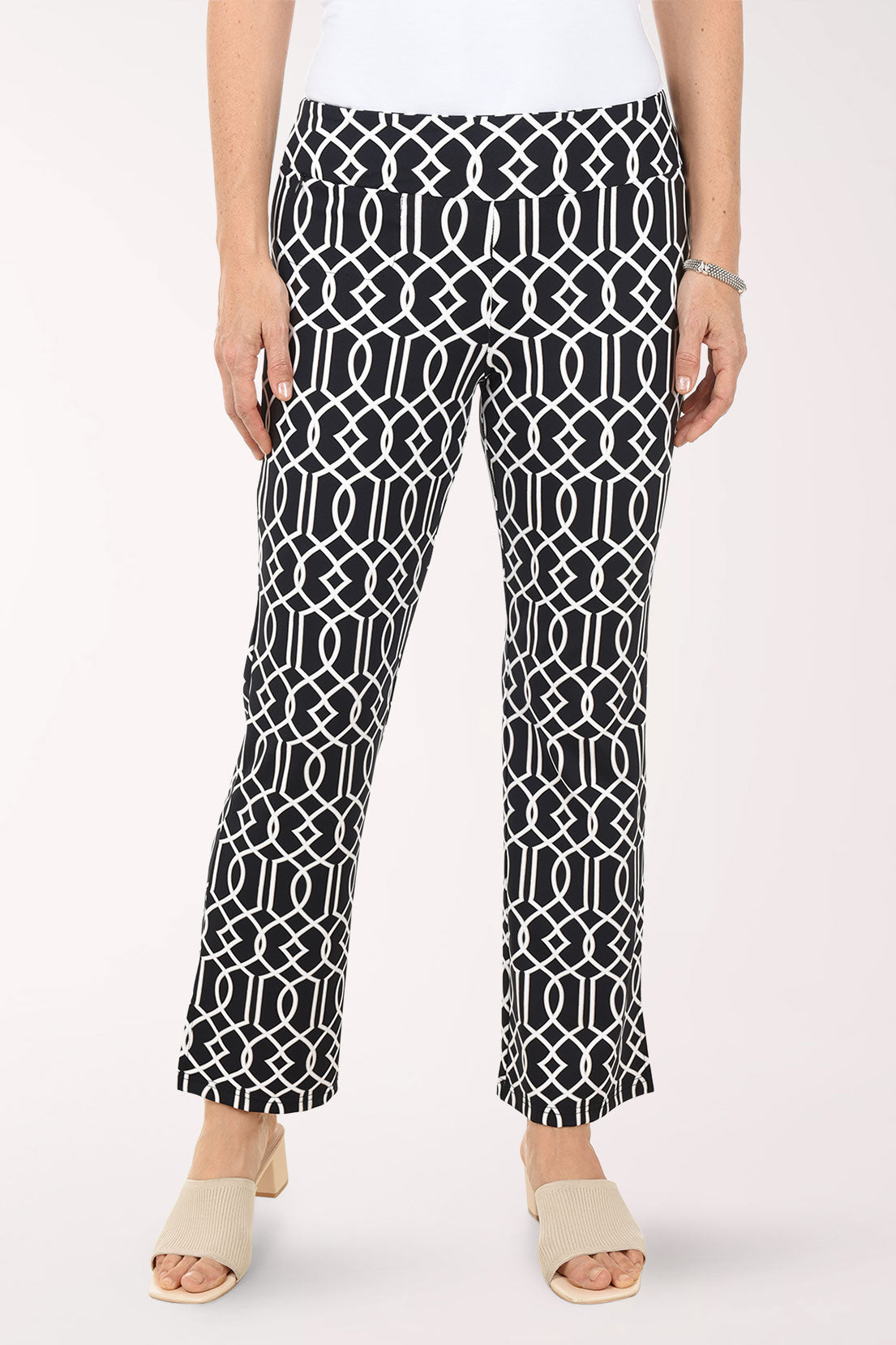 Person wearing black and white patterned pants on a white background