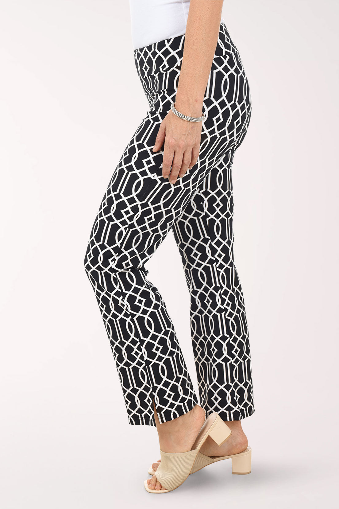 Person wearing black and white patterned pants on a white background