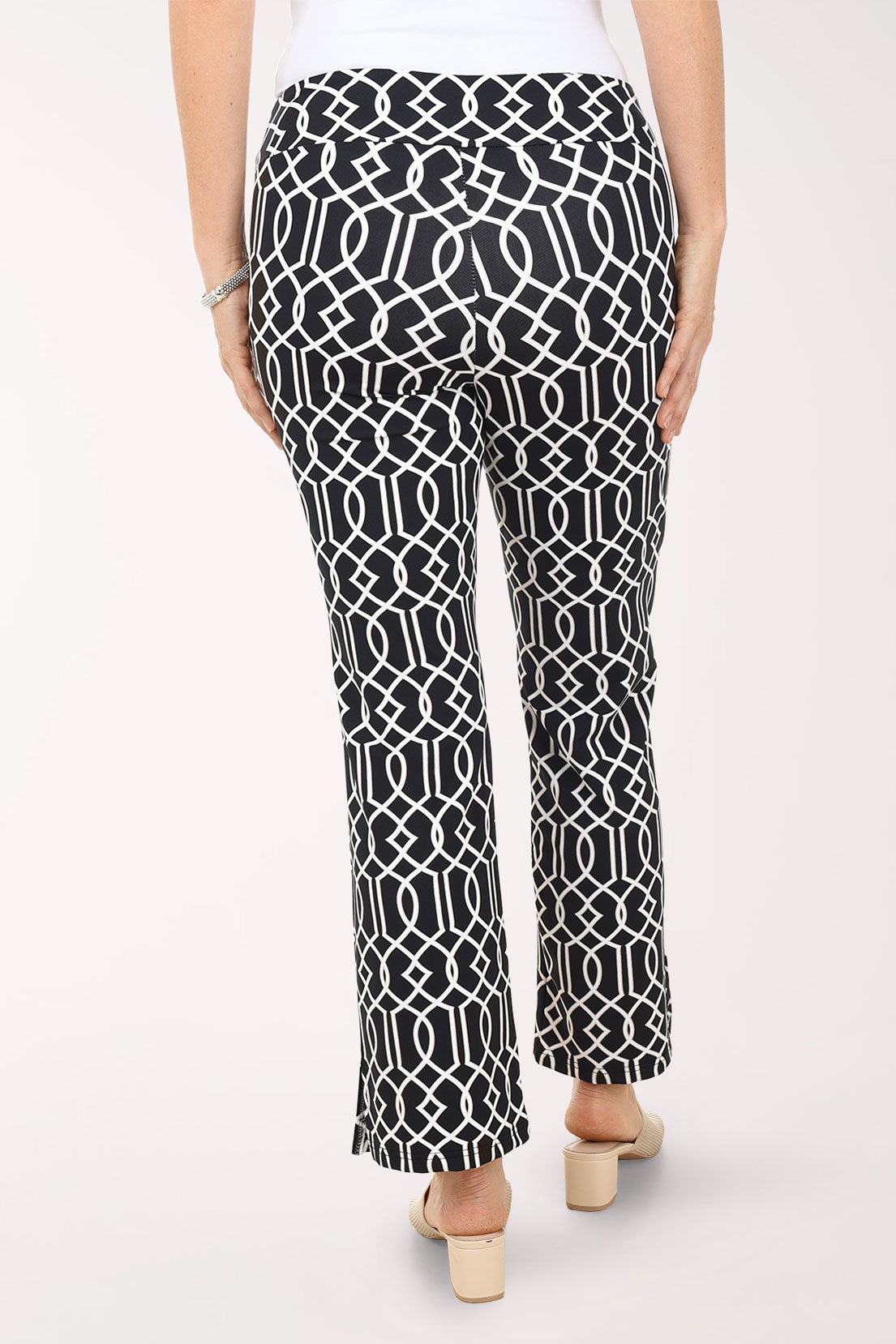 Person wearing black and white patterned pants on a white background