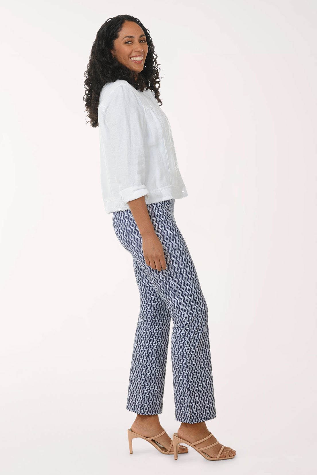 Woman wearing a white blouse and patterned pants on a white background