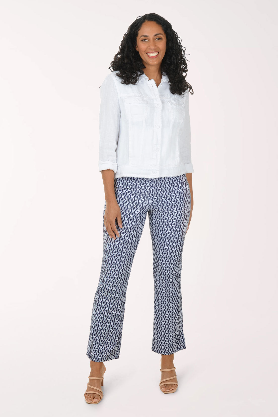 Woman wearing a white blouse and patterned pants on a white background