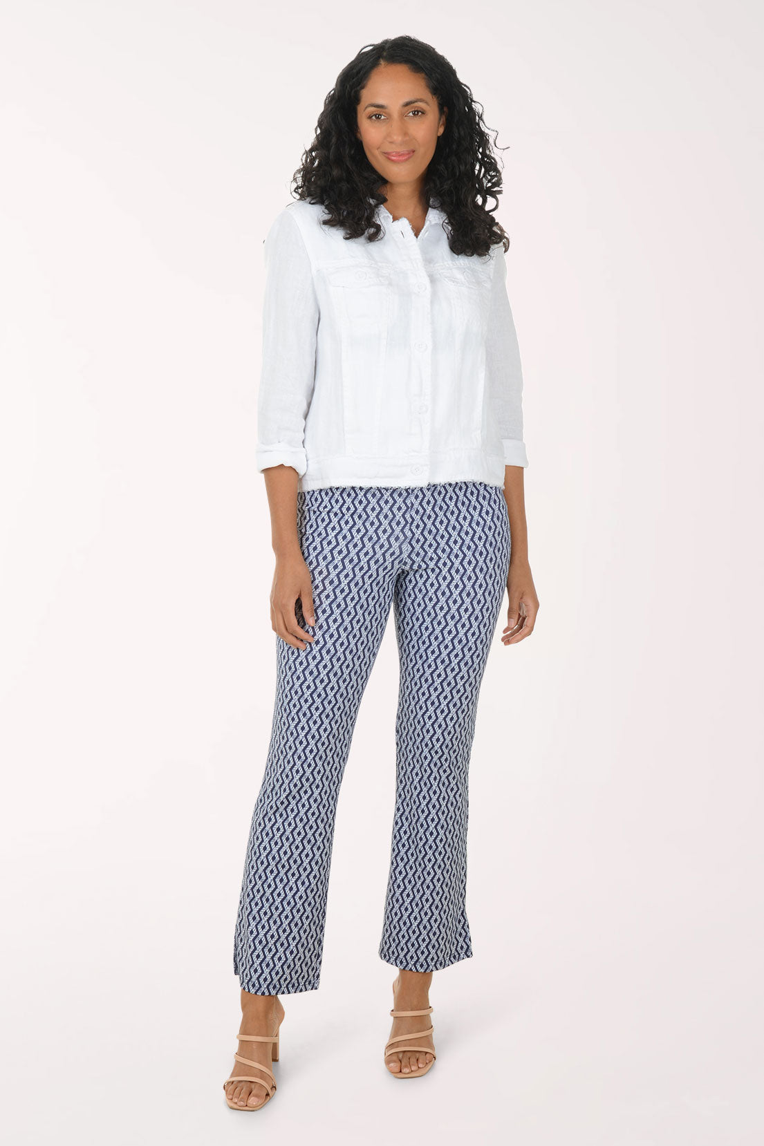 Woman wearing a white blouse and patterned pants on a white background