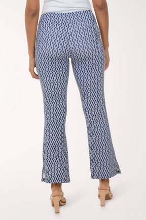 Woman wearing a white blouse and patterned pants on a white background