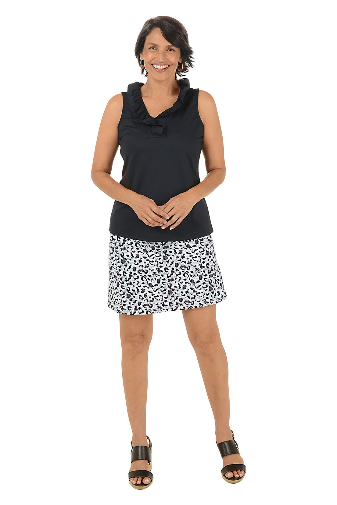 Woman wearing a black sleeveless top and patterned skirt on a white background