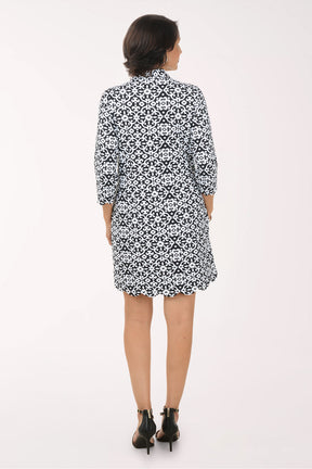 Woman wearing a black and white patterned dress on a white background
