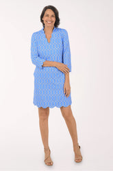 Woman wearing a blue dress with a white geometric pattern on a white background