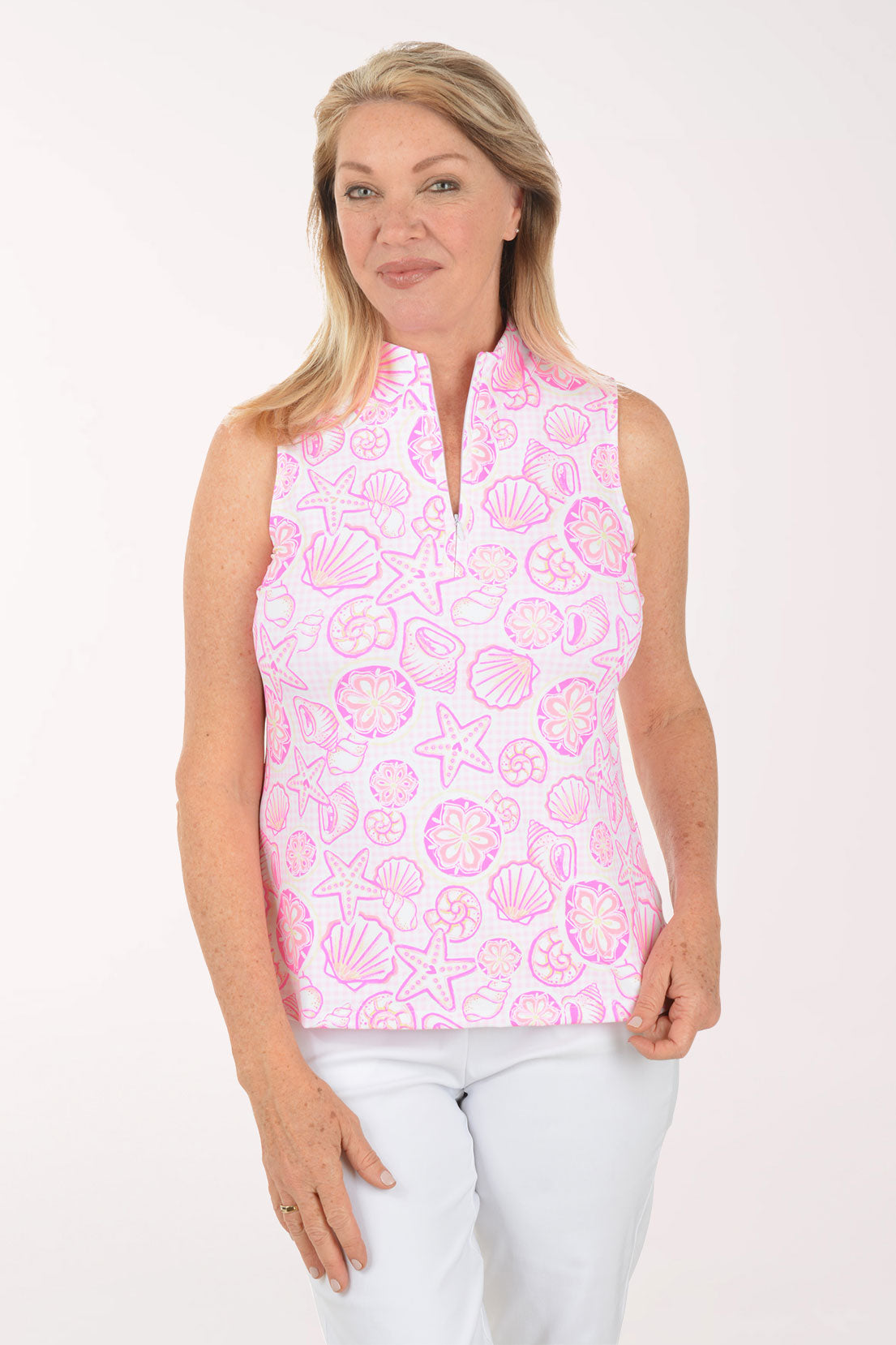 Woman wearing a pink sleeveless top with shell pattern on a white background