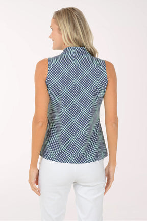 Woman wearing a sleeveless patterned top and white pants on a white background