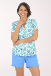 Woman wearing a blue floral patterned shirt and matching shorts on a white background