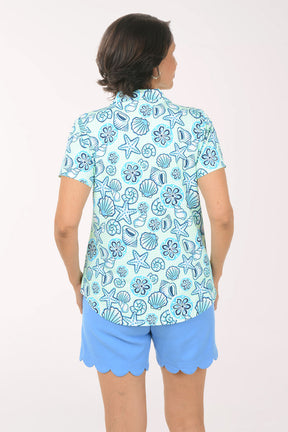 Woman wearing a blue floral patterned shirt and matching shorts on a white background
