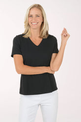 Woman wearing a black t-shirt and white pants on a white background