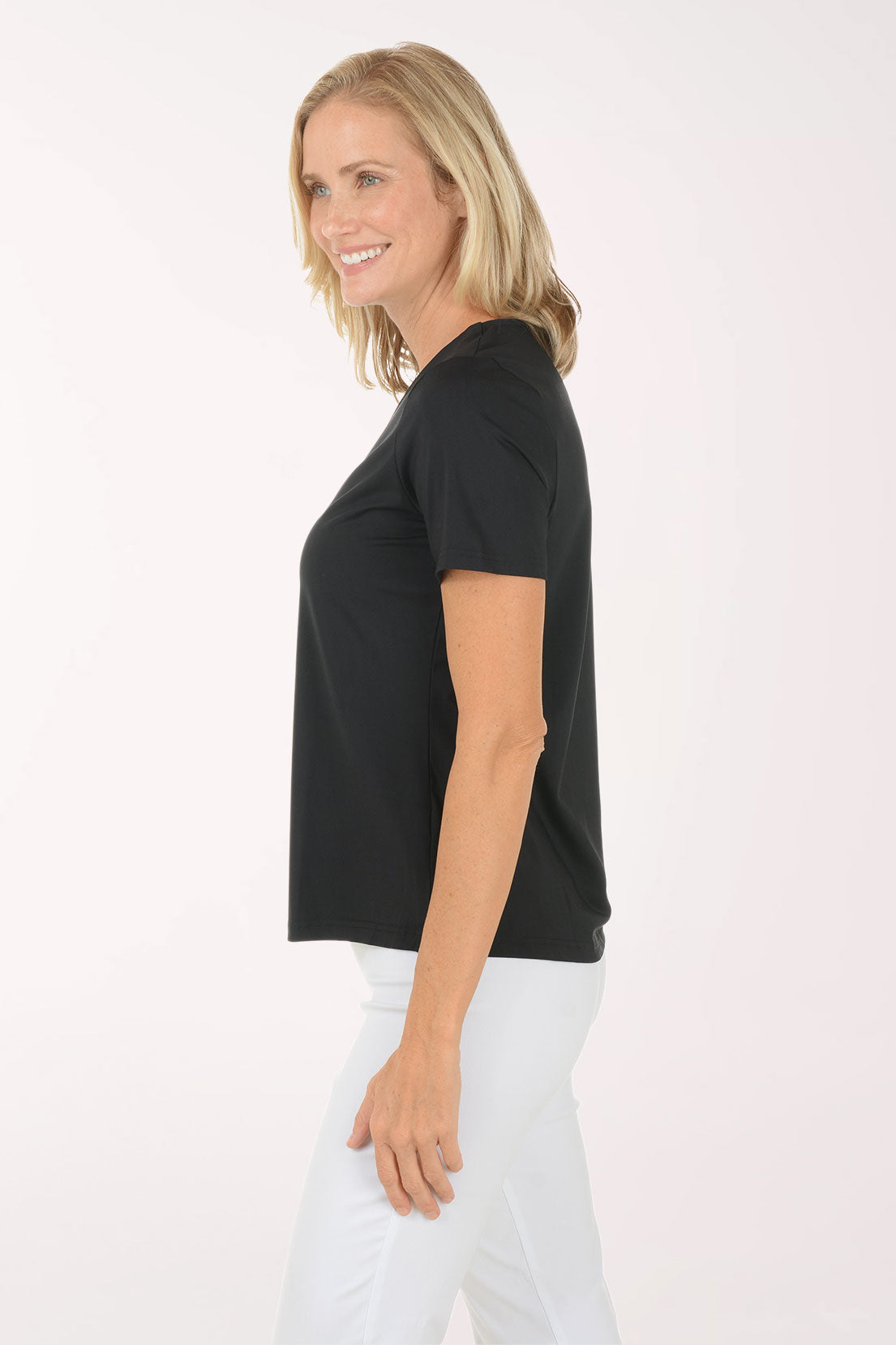 Woman wearing a black t-shirt and white pants on a white background