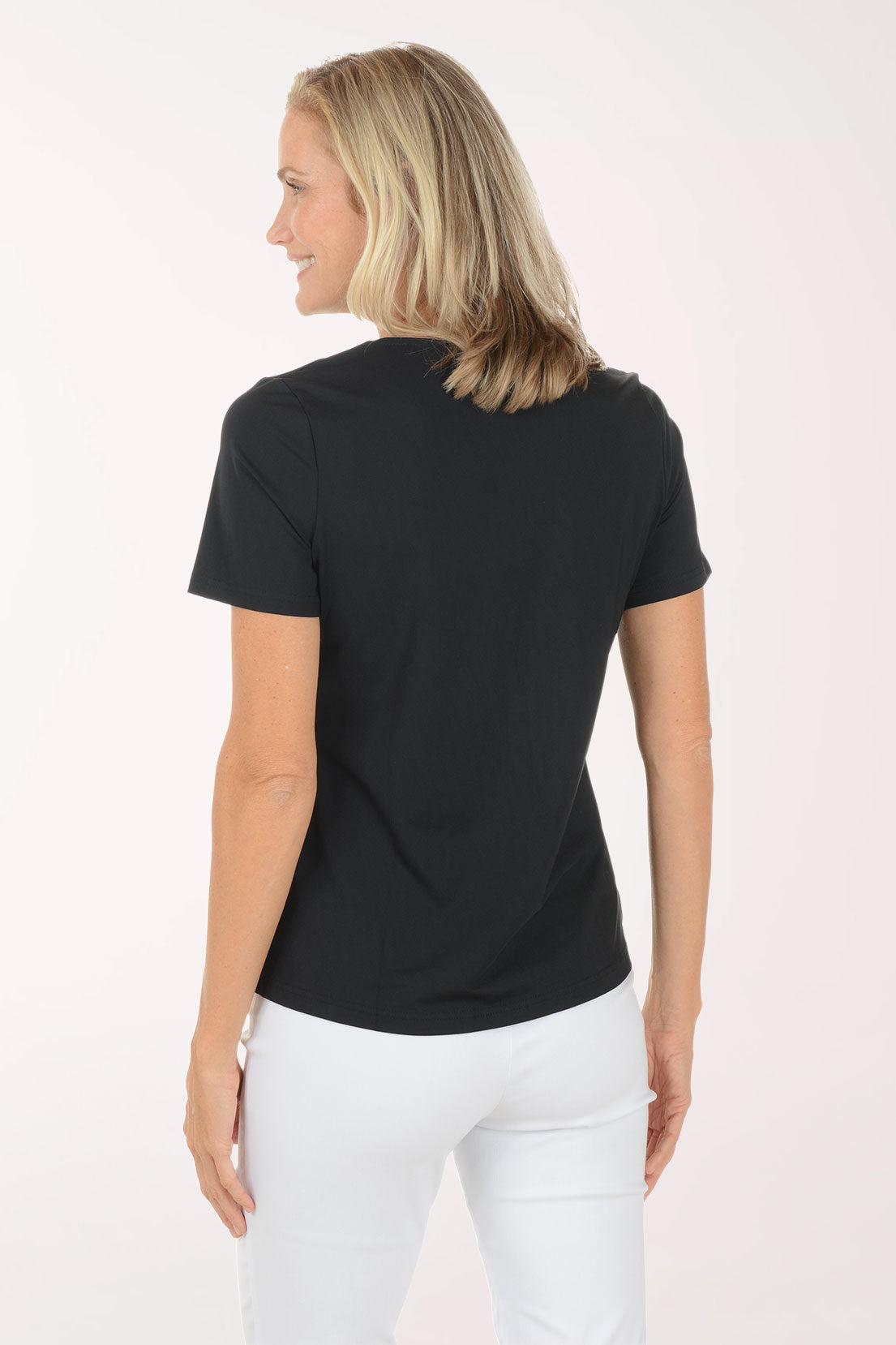 Woman wearing a black t-shirt and white pants on a white background