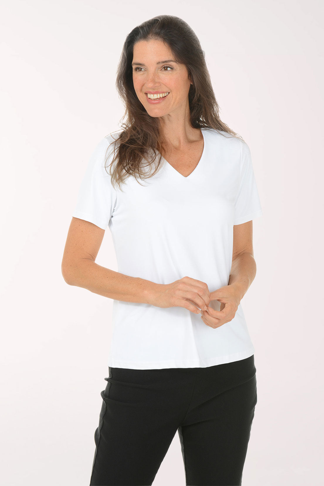 Woman wearing a white V-neck shirt and black pants on a white background