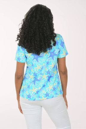 Woman wearing a blue starfish patterned shirt on a white background