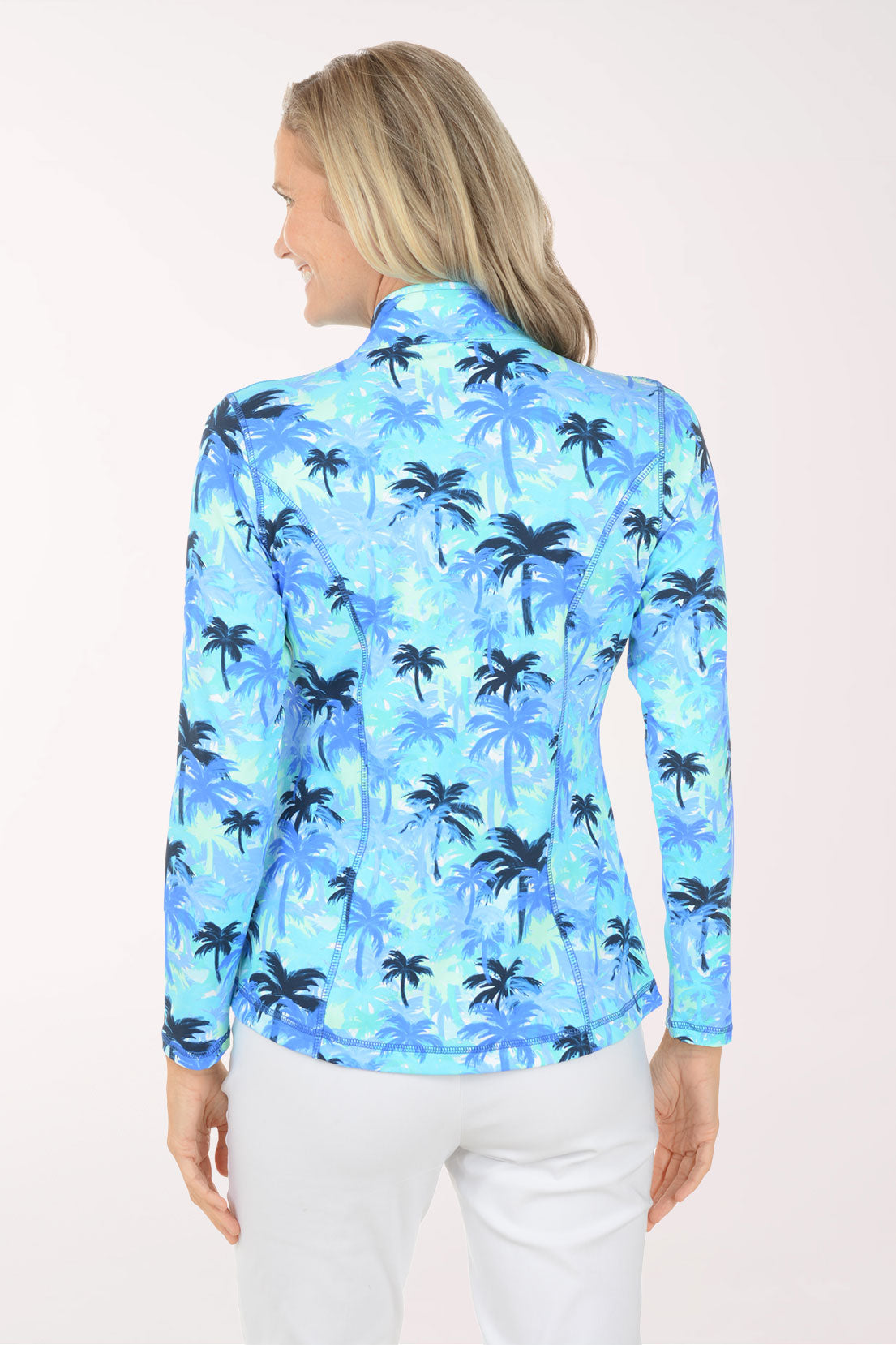 Woman wearing a blue palm tree patterned jacket on a white background
