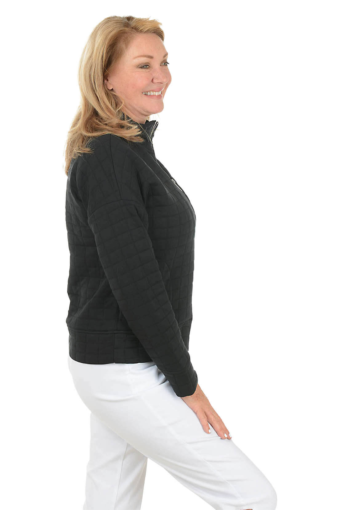 Woman wearing a black quilted jacket on a white background. Side shot.