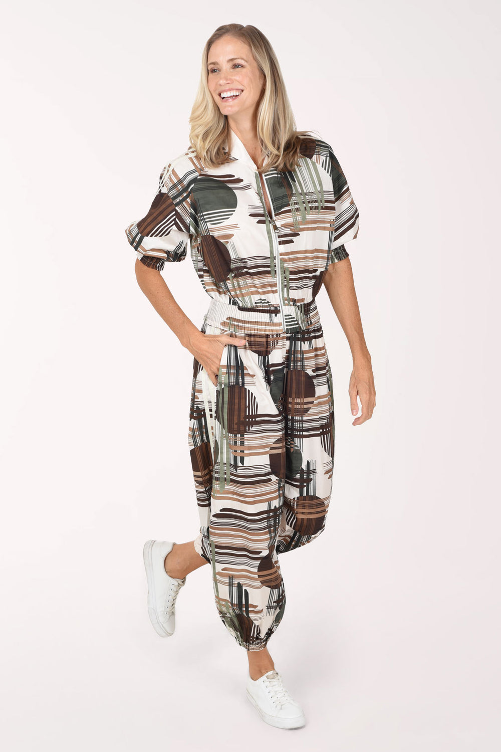 Woman wearing camouflage plaid patterned ankle length joggers with contrast stripes on side leg.