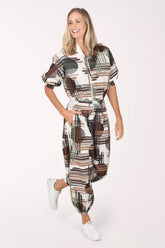 Woman wearing camouflage plaid patterned ankle length joggers with contrast stripes on side leg.