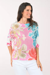 Woman wearing a colorful floral sweater against a white background