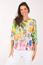 Woman wearing a colorful shirt with fruit design on a white background