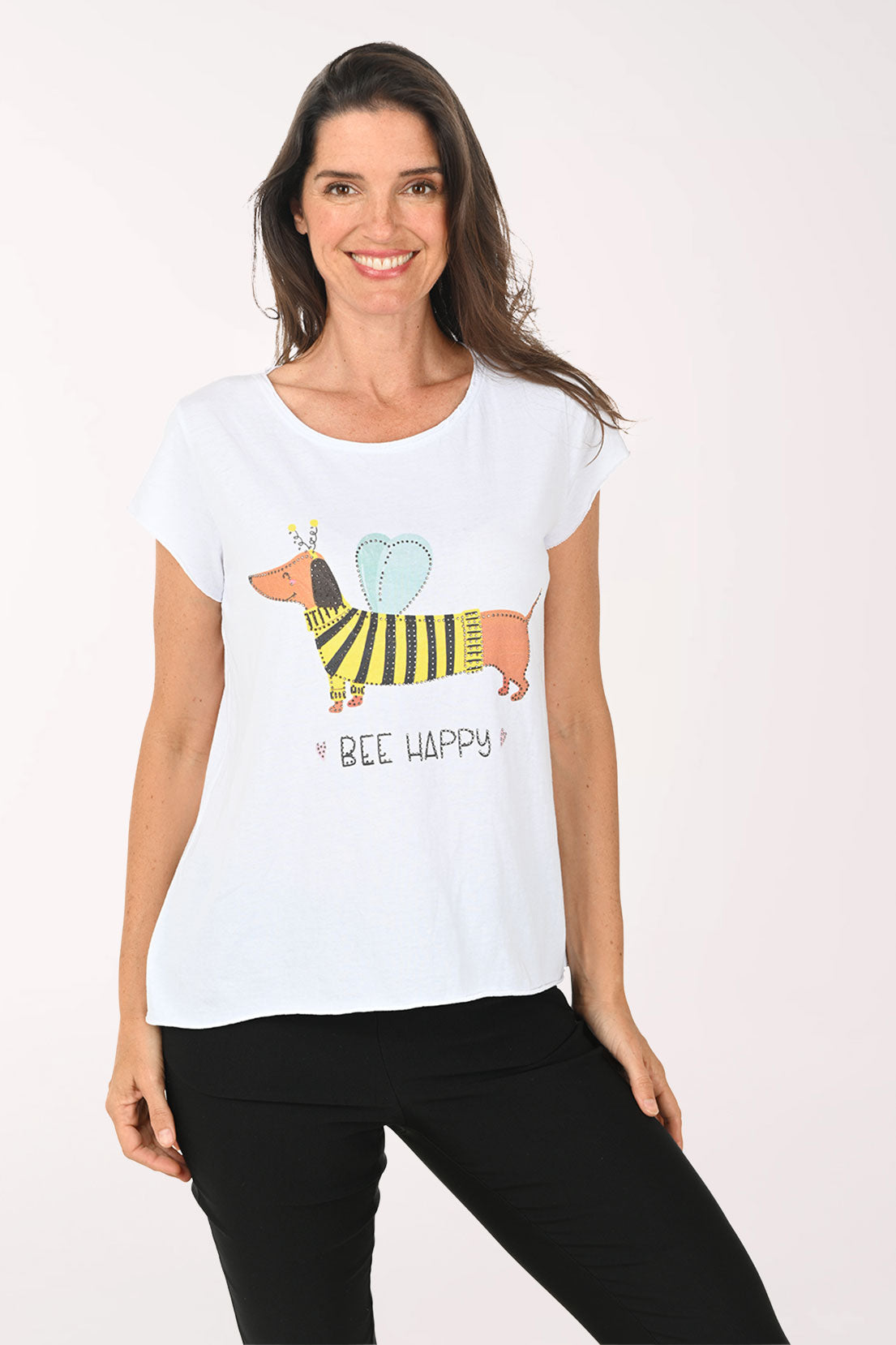 Woman wearing a white t-shirt with a colorful dog graphic and 'Bee Happy' text on a plain background
