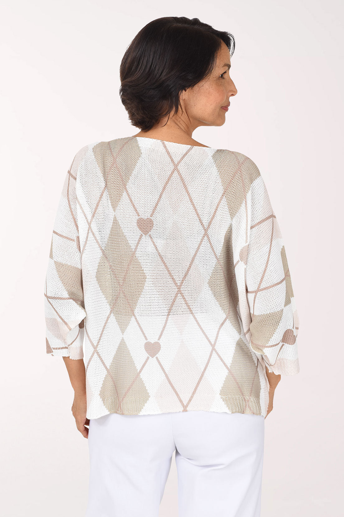Back view of the sweater with beige and white argyle and small hearts scattered across the back