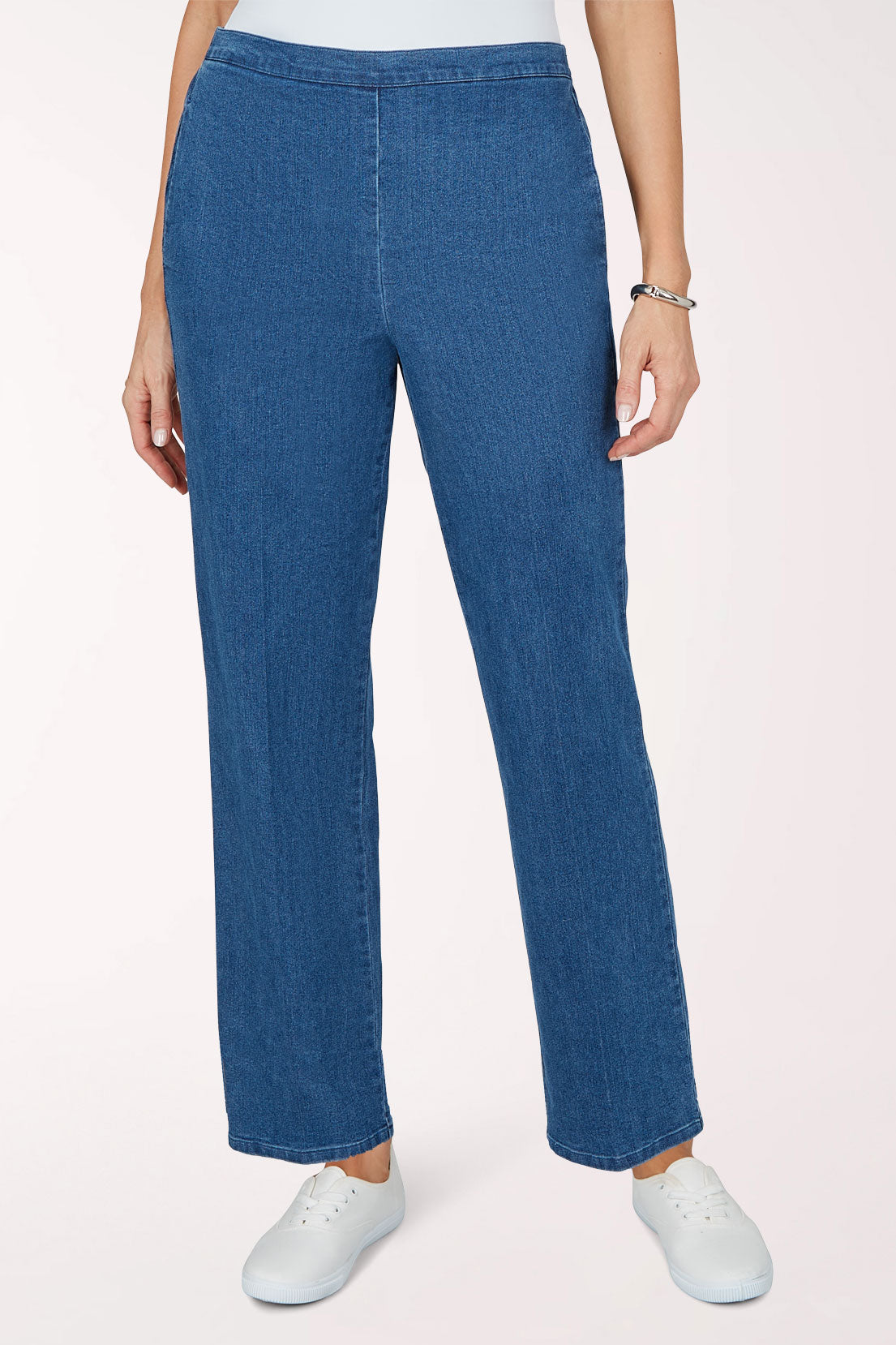 Front view of medium indigo stretch denim pants with a relaxed straight full-length leg and stretch waistband, worn with white sneakers.