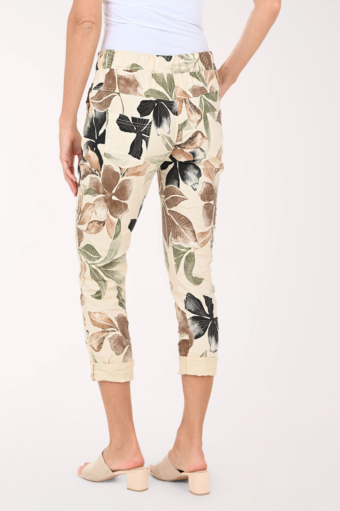 Capri pants with floral pattern worn by a person on a white background